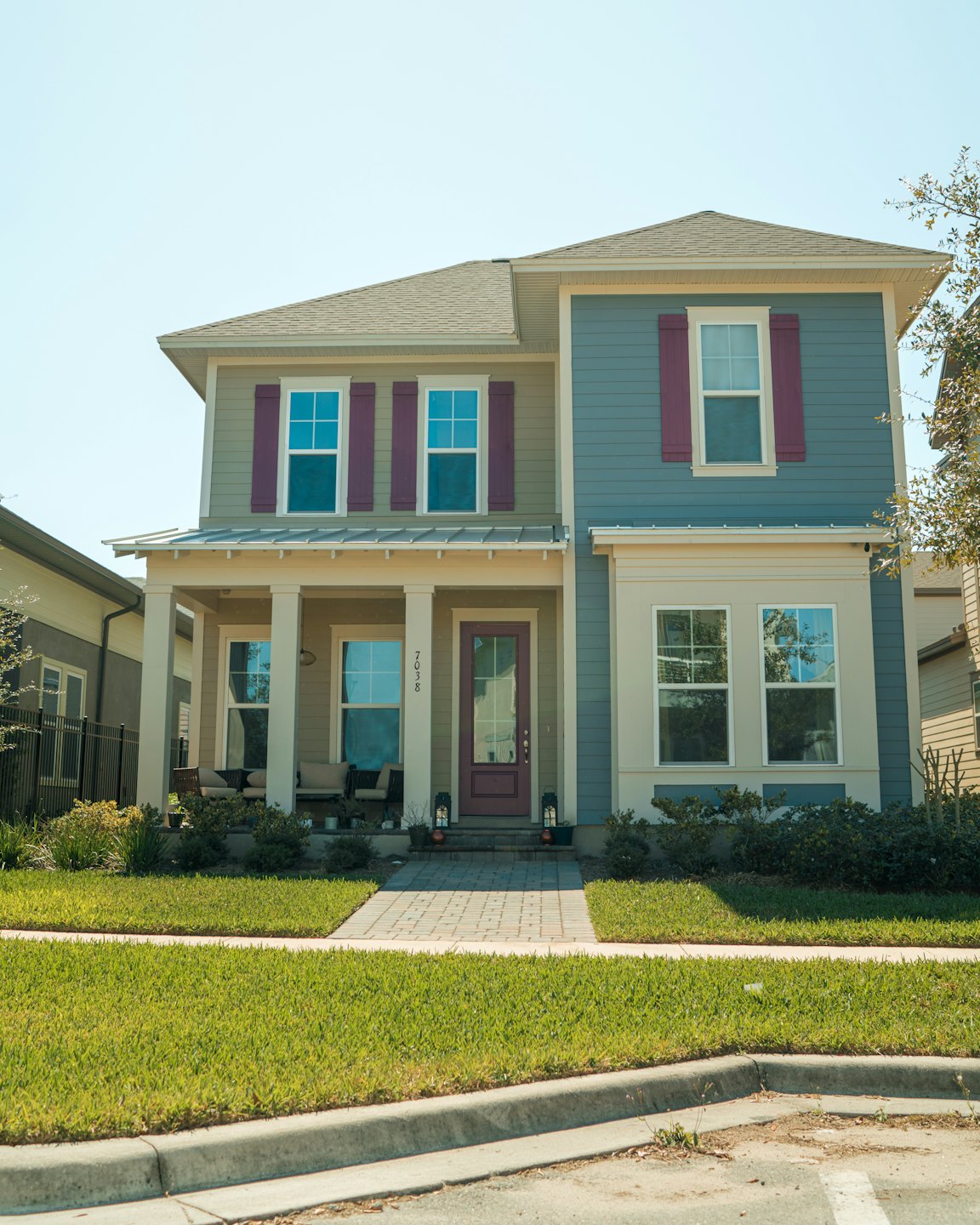 A two-story suburban house with multi-colored siding and a welcoming front porch.